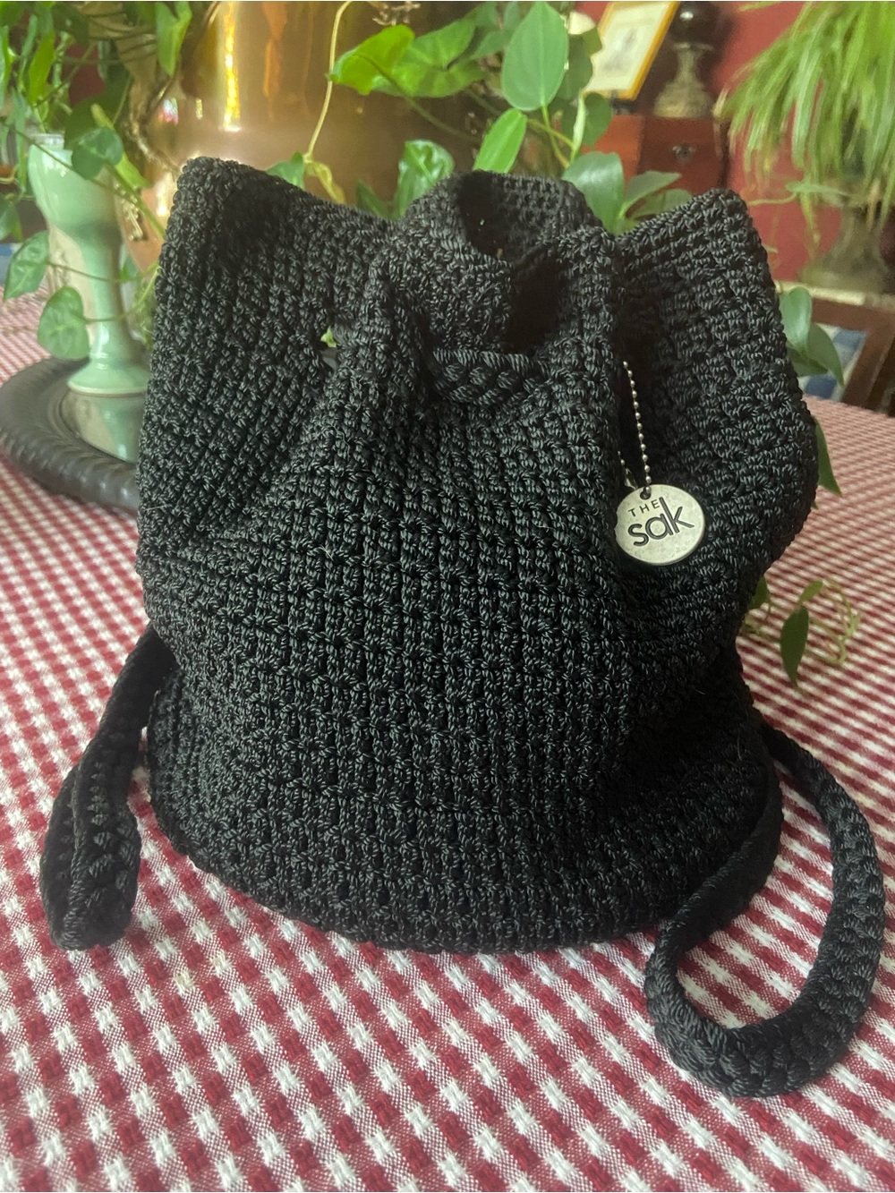 The Sak black crochet mini backpack. Drawstring/strap closure.